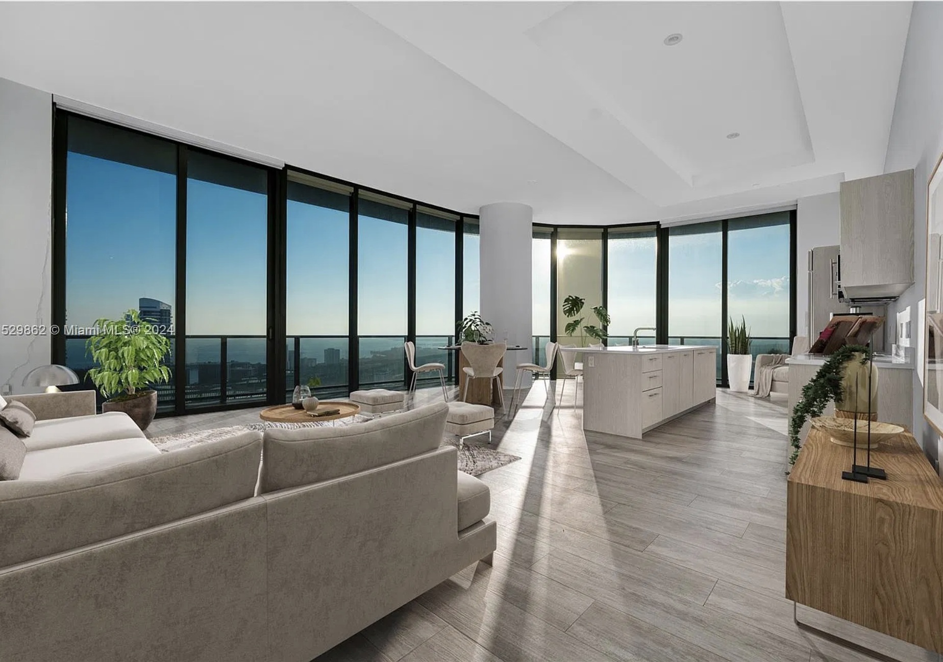 Sunlit open-plan residence with floor-to-ceiling windows, a kitchen island and bay views