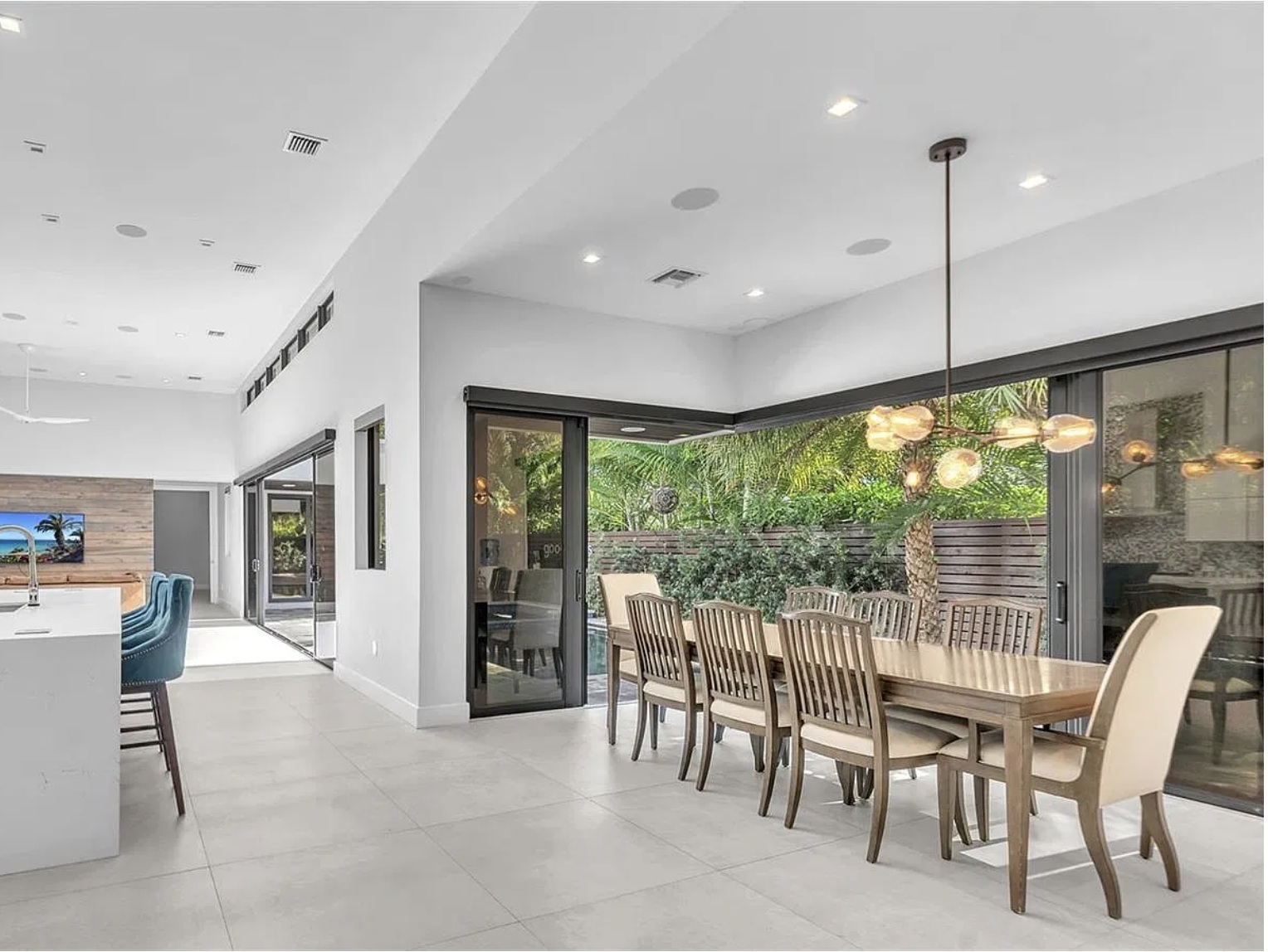 Bright dining room opening onto a palm-filled outdoor terrace